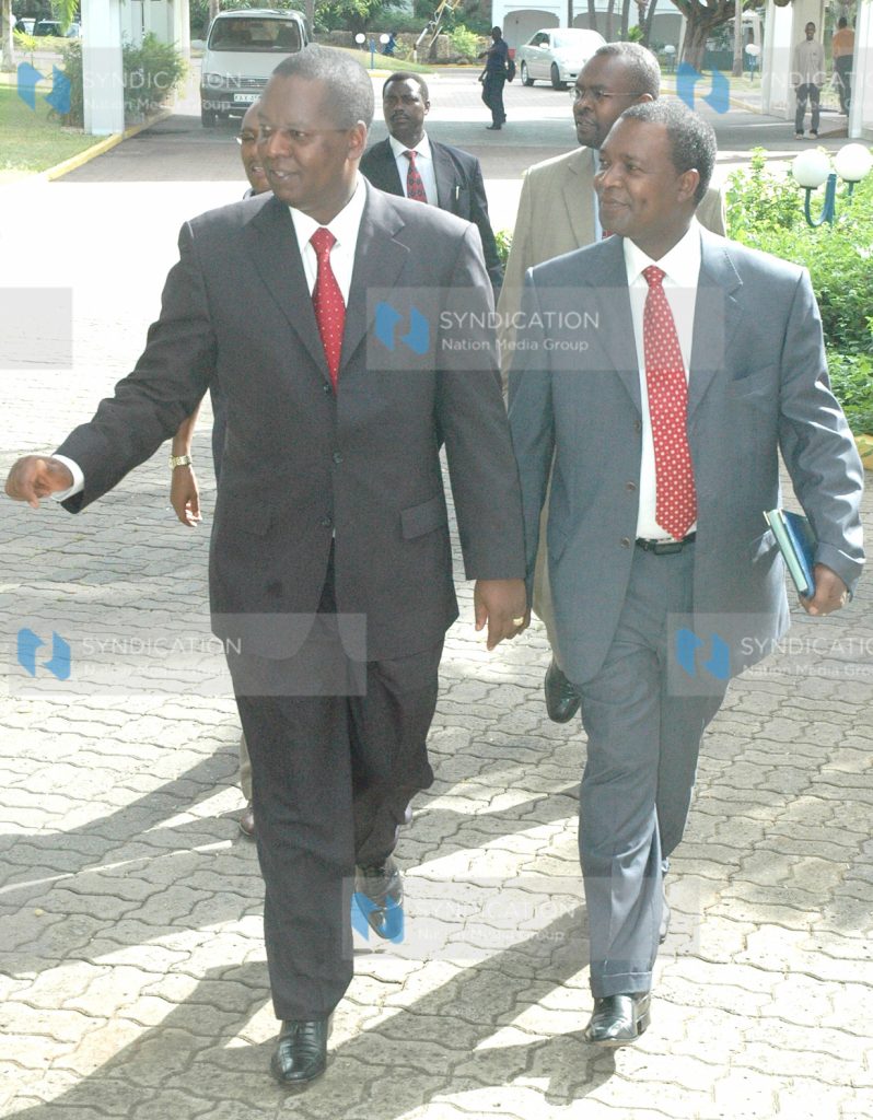 Kenya's Finance Minister Amos Kimunya is escorted by the governor of the CBK Professor Ndung'u Njuguna