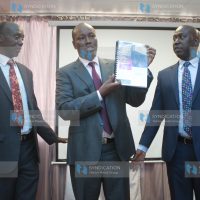 James Tuitoek (left) hands over its findings to Nakuru County Governor Lee Kinyanjui (centre)