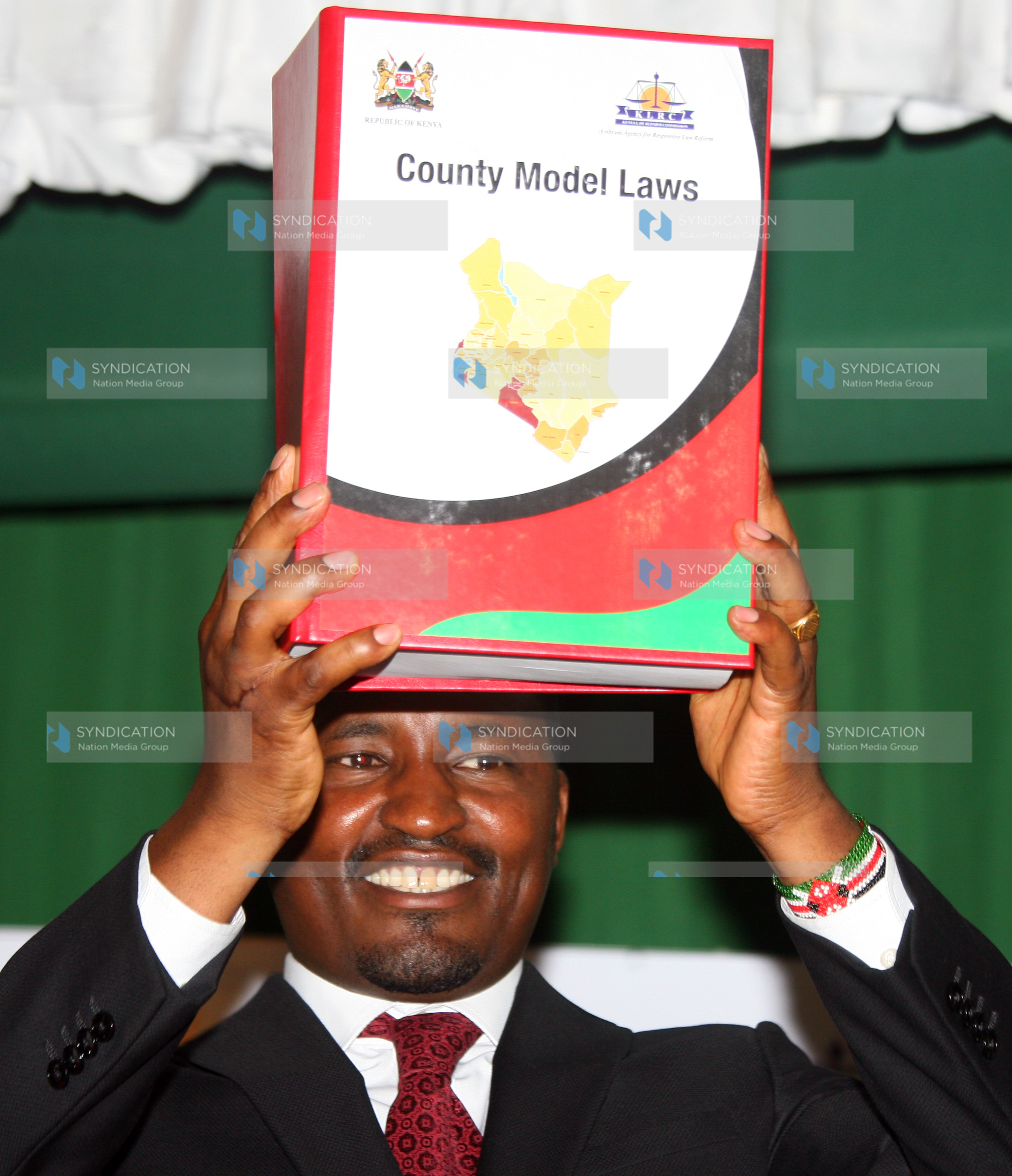 Mwangi Kiunjuri lifts a book containing County Model Laws