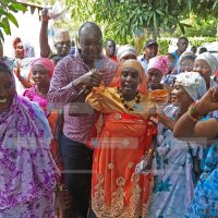 Kisumu Senator Tom Ojienda (C) joins in a dance with the Nubian community members
