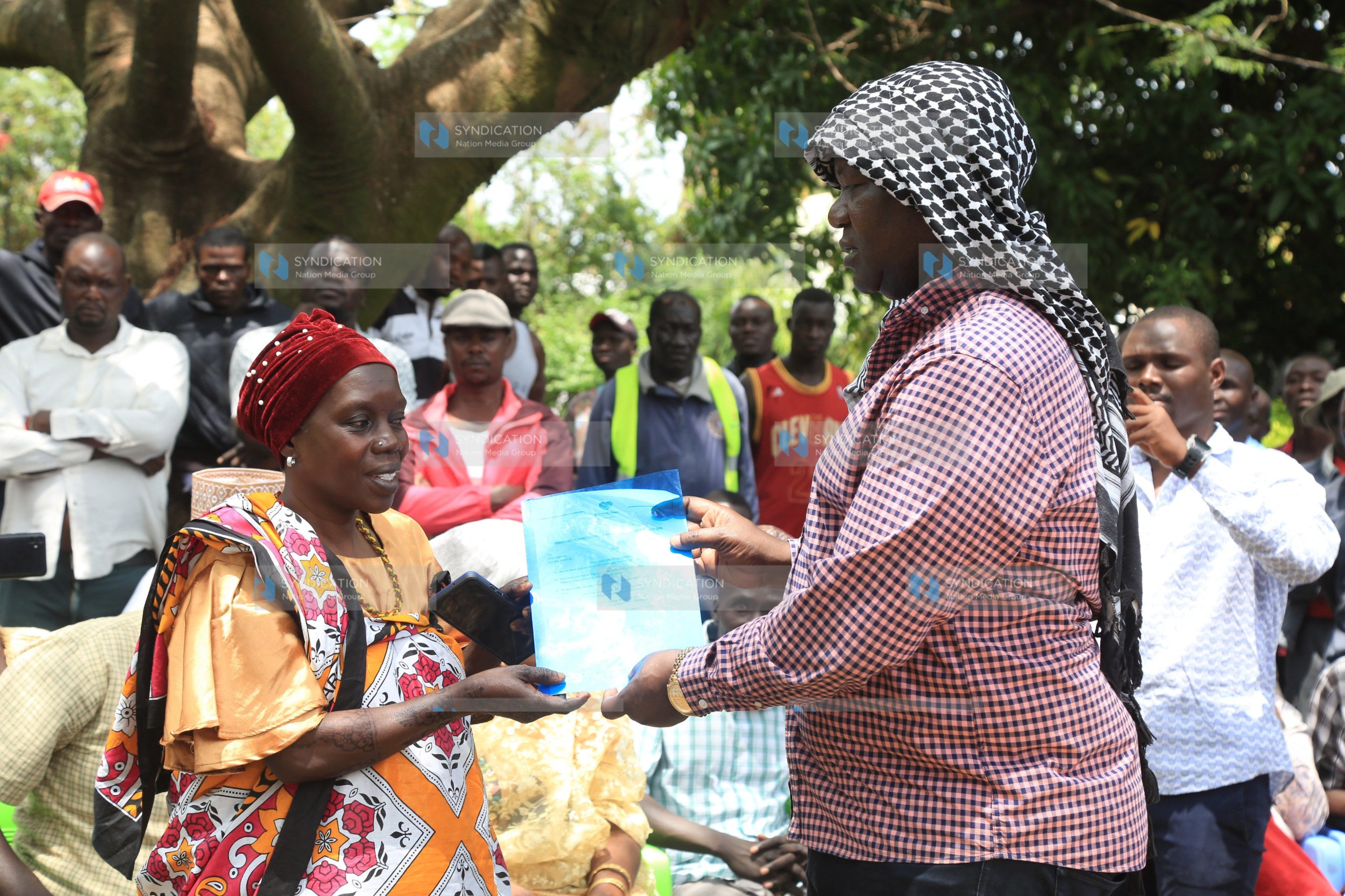 Kisumu Senator Tom Ojienda (R) receives a petition from Mama Fatuma Hamisi