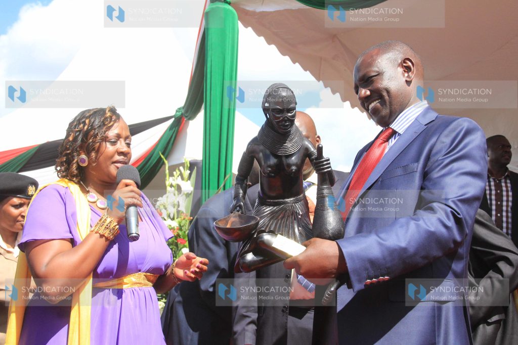 Murang'a county women representative Sabina Chege, presents a sculpture gift to Deputy President William Ruto