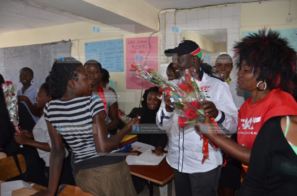Jubilee deputy leader William Ruto presents flowers to students of Buruburu College
