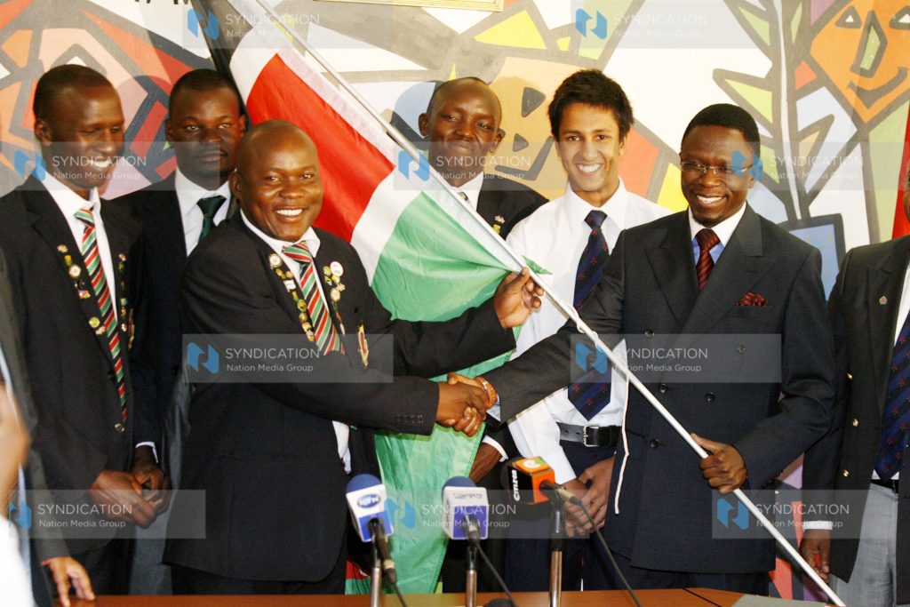 Sports Minister Ababu Namwamba hands over the national flag to National Golf team captain David Opati