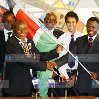 Sports Minister Ababu Namwamba hands over the national flag to National Golf team captain David Opati