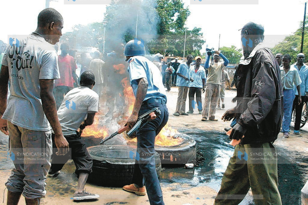 Police officer and protesters jointly put off fire from burning tires