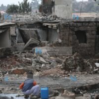 child play near a destroyed building rubble in Kibera slum, after the post-election violence