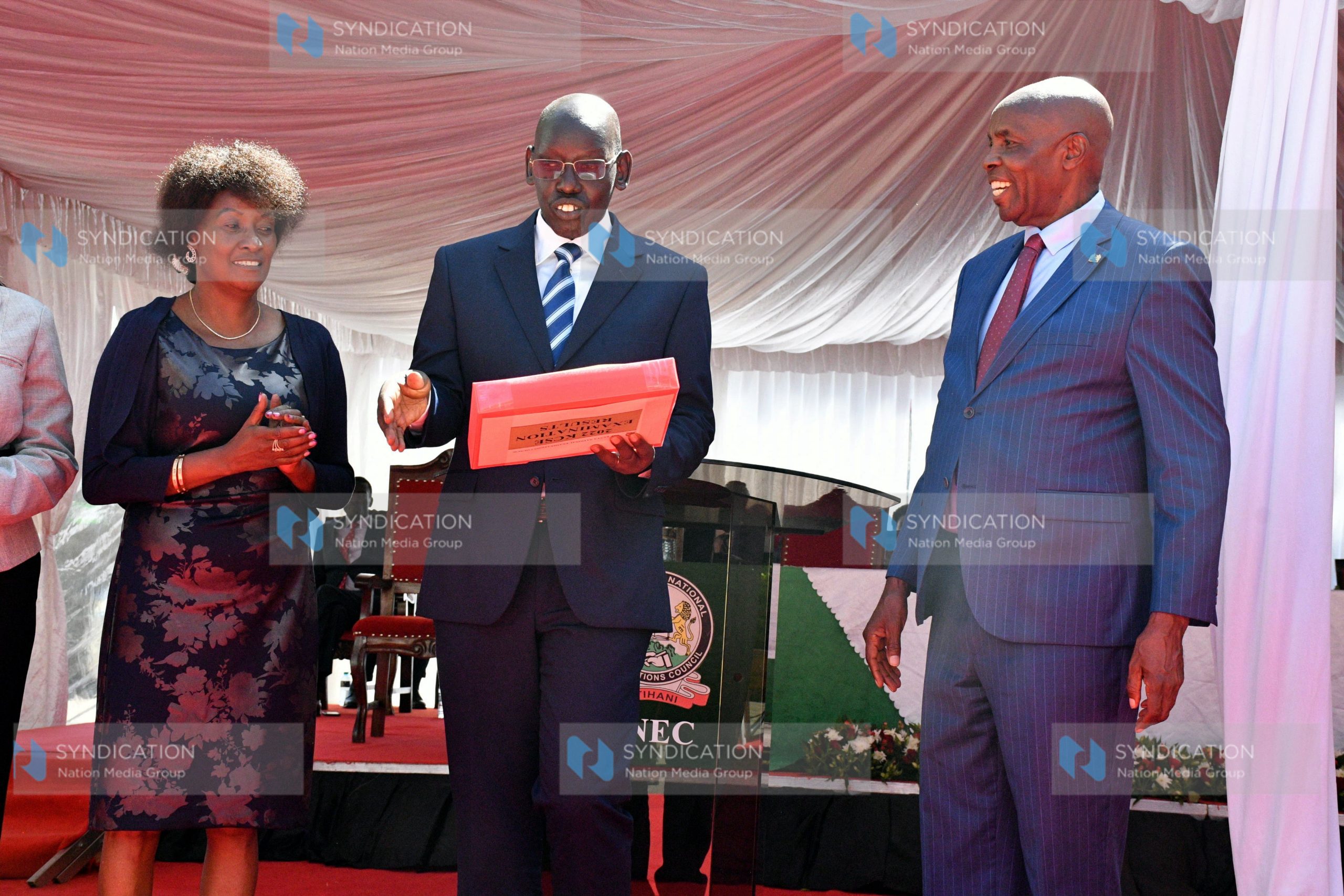 Basic Education PS Belio Kipsang holds up copies of the 2022 KCSE exam results