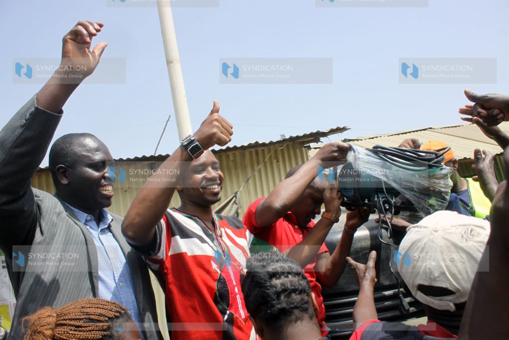Boniface Mwangi, Starehe MP aspirant, with youth at Mukuru kwa Reuben