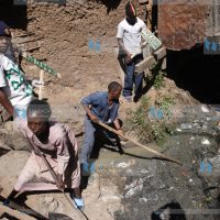Members of Anointed Youth group with the residents participate in a cleanup of Madoya village in Huruma Estate