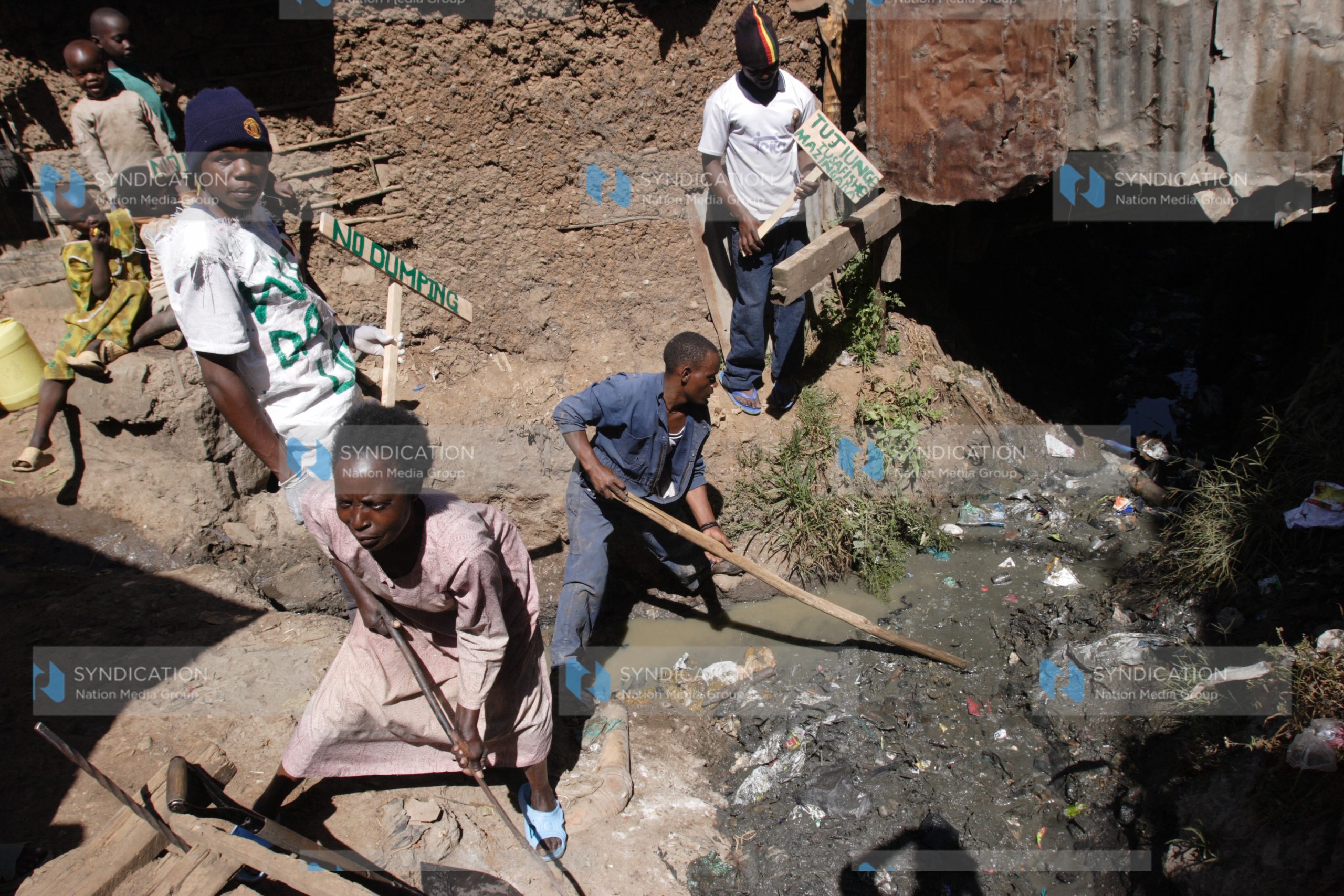 Members of Anointed Youth group with the residents participate in a cleanup of Madoya village in Huruma Estate