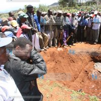 Members of the public mill at a scene where seven bodies of people from one family who were killed during post-election violence