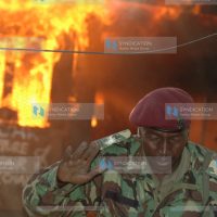 A General service unit police officer runs for his life from a fire break during the post-election violence