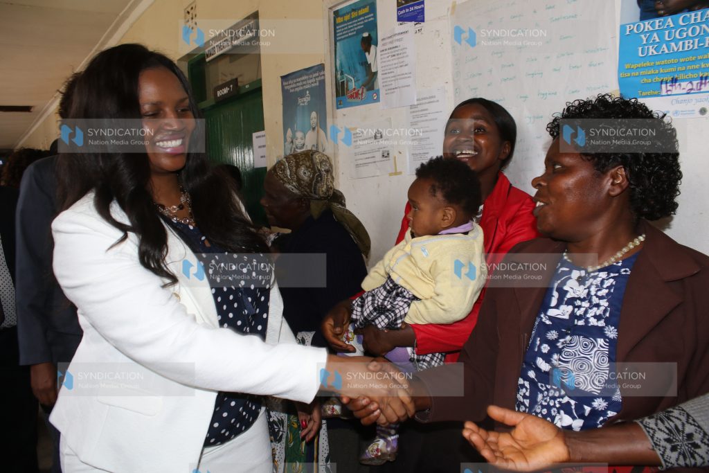 Phoebe Munya, wife of Meru Governor Peter Munya, shakes hands with women at Mikumbune Dispensary