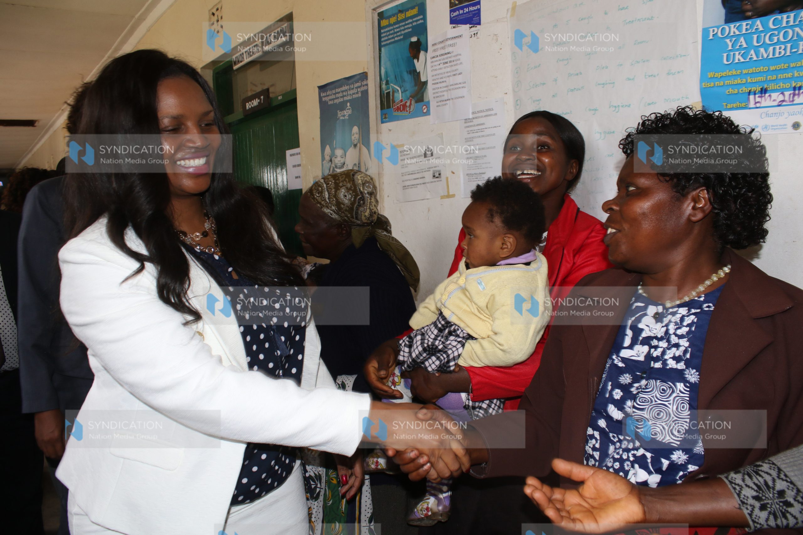 Phoebe Munya, wife of Meru Governor Peter Munya, shakes hands with women at Mikumbune Dispensary