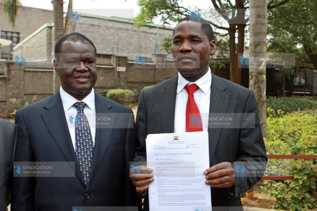 Peter Munya hold a copy of the petition to the British Government