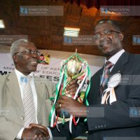 Education Minister Professor Sam Ongeri presents a trophy to Starehe Boys Center choir director Mr. Fraklin Etyang'