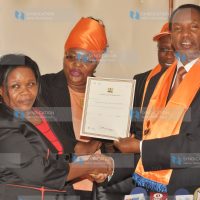 Henry Kosgey (right) receives the party full compliance certificate