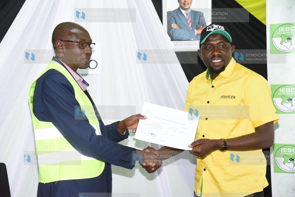 Elgeyo Marakwet Senator Kipchumba Murkomen receives a certificate from Charles Mutai