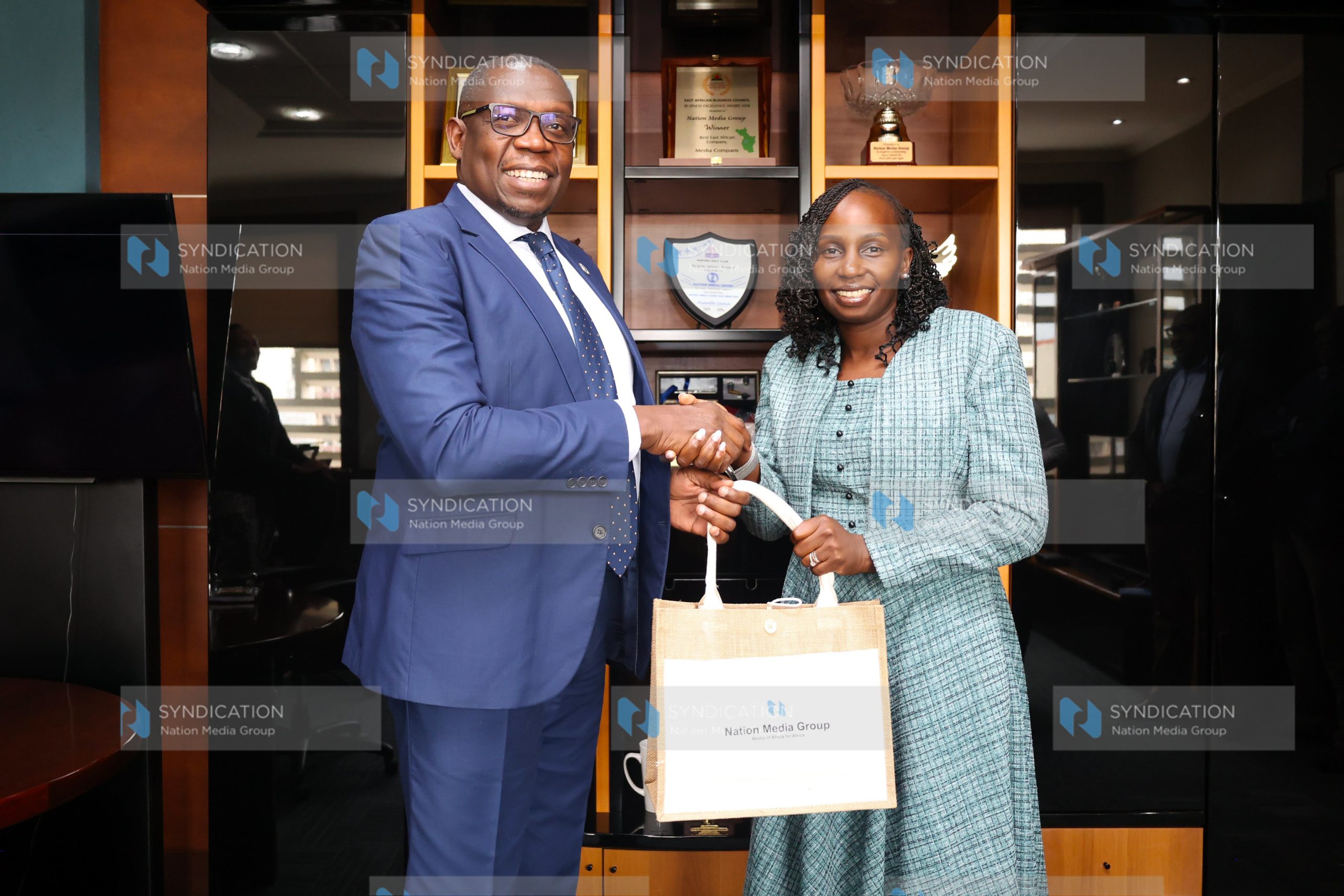 LSK President Faith Odhiambo receives a gift from NMG Managing Director and CEO Geoffrey Odundo