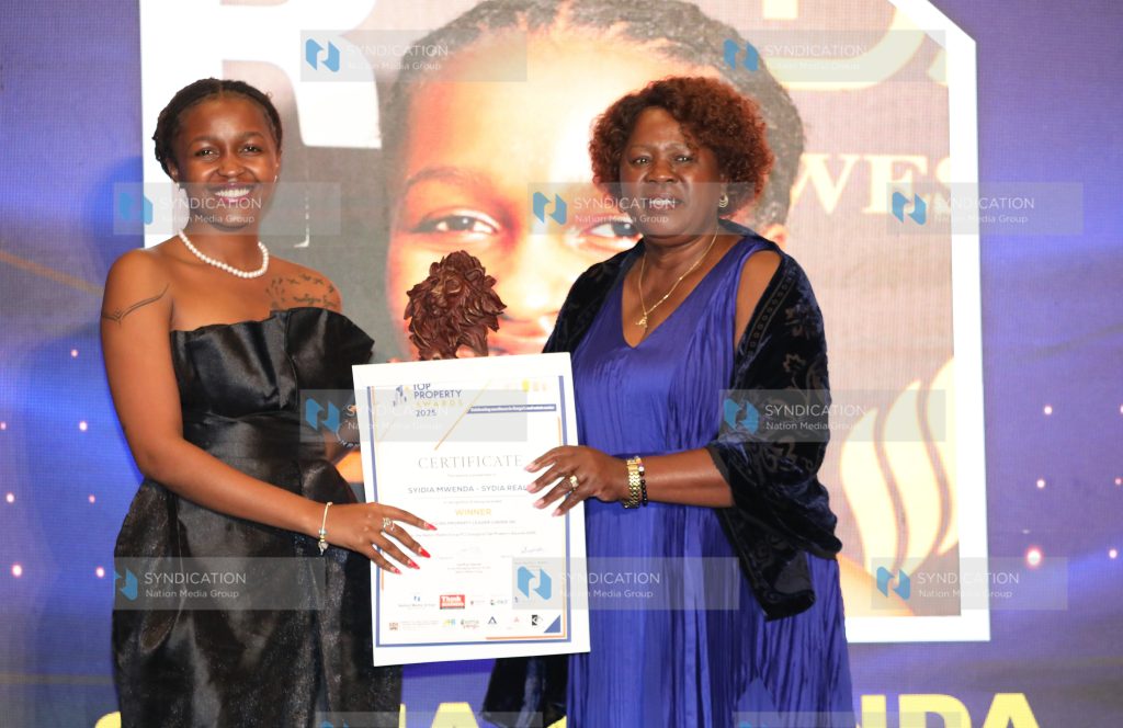 Cabinet Secretary for the Ministry of Lands, Housing and Public Works Alice Wahome presents an award to Sydia Mwenda of Sydia Realty