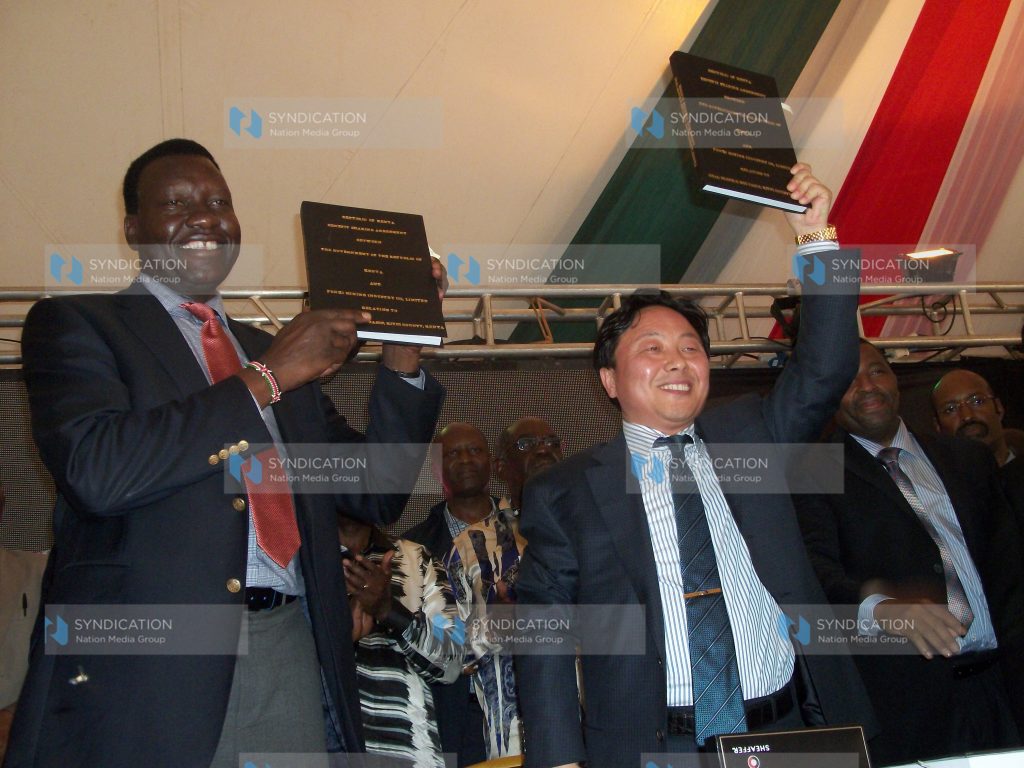 Davis Chirchir and Fenxi Mining Vice President Yang Wusheng exchange the coal mining contract documents
