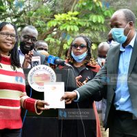 Thirdway Alliance National Chairman Miruru Waweru hands over a copy of the party’s constitution to Acting Party Leader Dr. Angela Mwikali