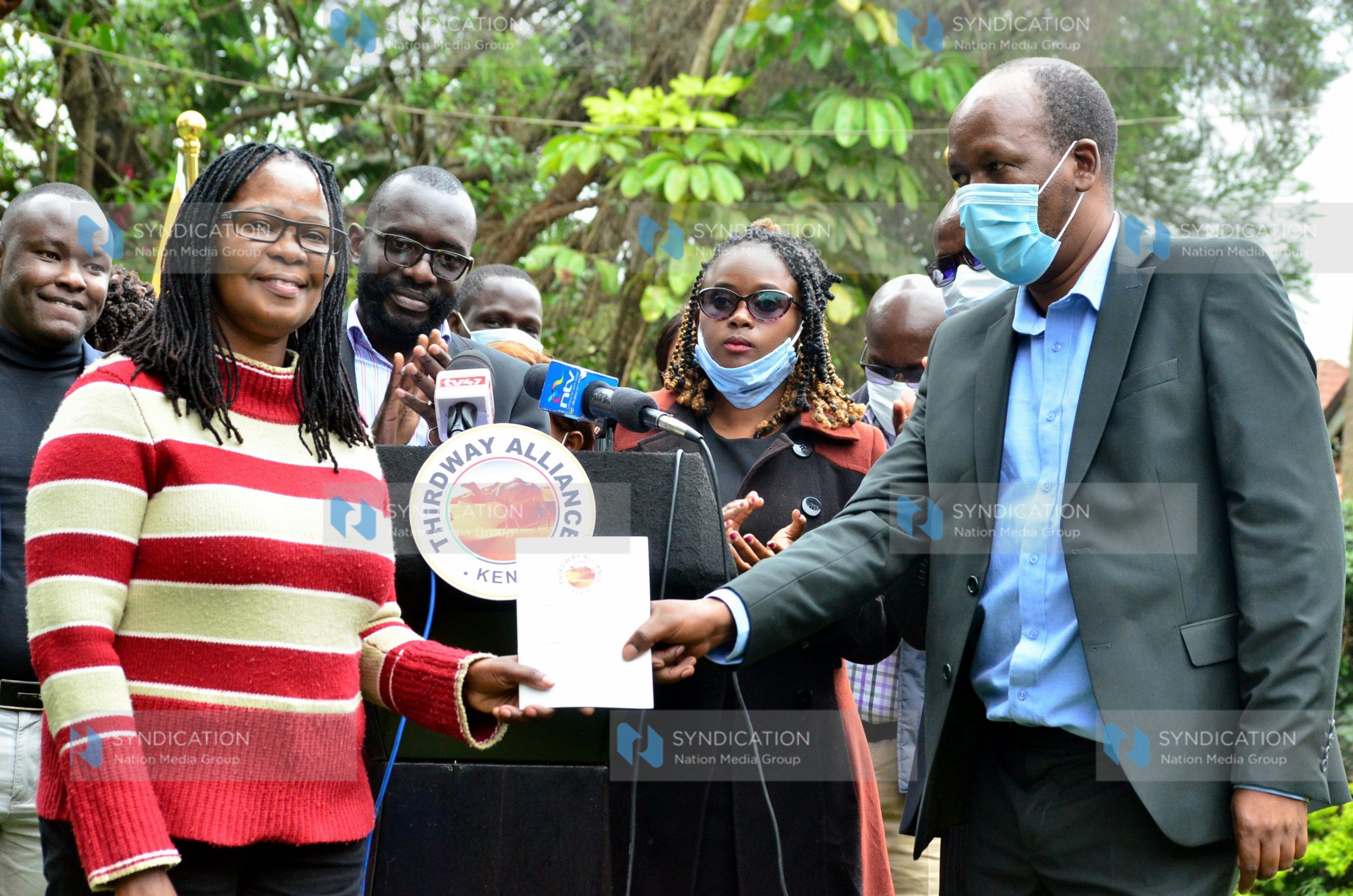 Thirdway Alliance National Chairman Miruru Waweru hands over a copy of the party’s constitution to Acting Party Leader Dr. Angela Mwikali