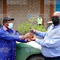 Ministry of Environment and Forestry Cabinet Secretary Mr. Keriako Tobiko (left) presents a tree seedling to NMG CEO Stephen Gitagama