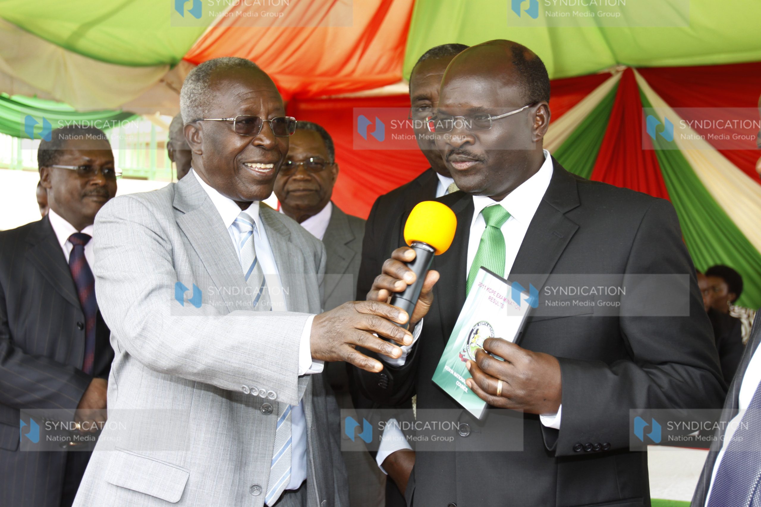 Minister for Education prof Sam Ongeri (left) hands over exams results to the Permanent Secretary prof James Ole Kiyiapi