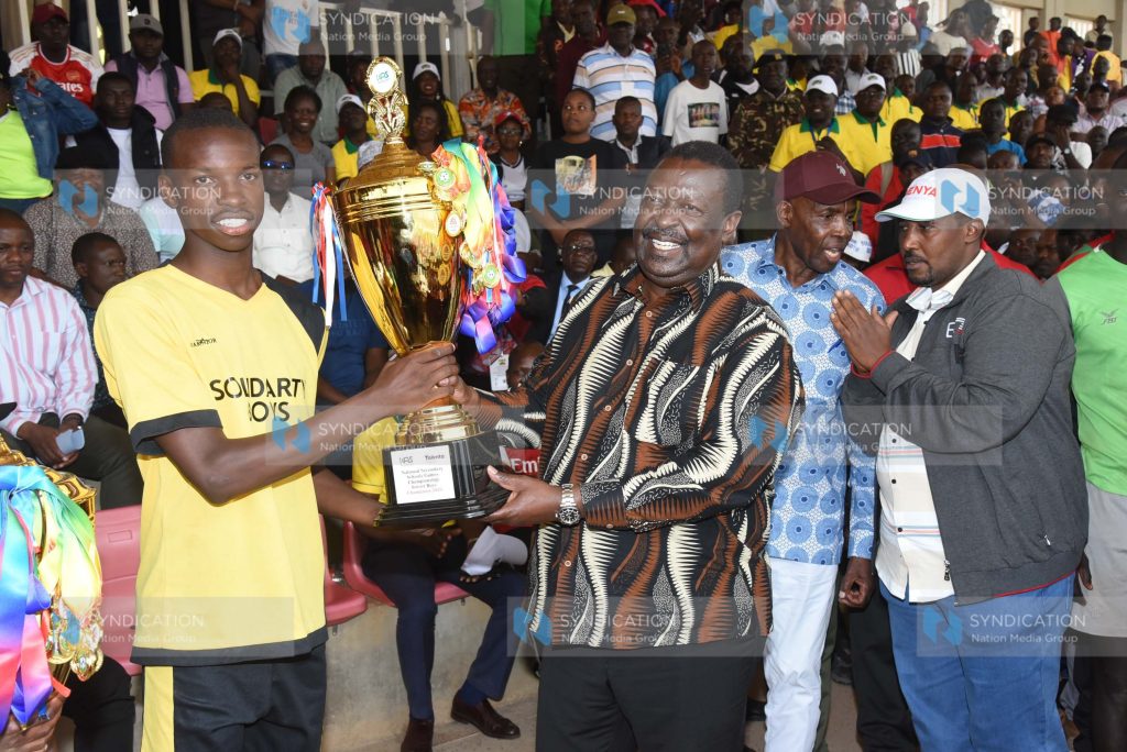 Prime Cabinet Secretary Musalia Mudavadi presents a trophy to Emmanuel Wanjala