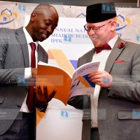 IPF Chief Executive Officer James Muraguri reads through a report with Office of the Prime Cabinet Secretary CAS Isaac Mwaura