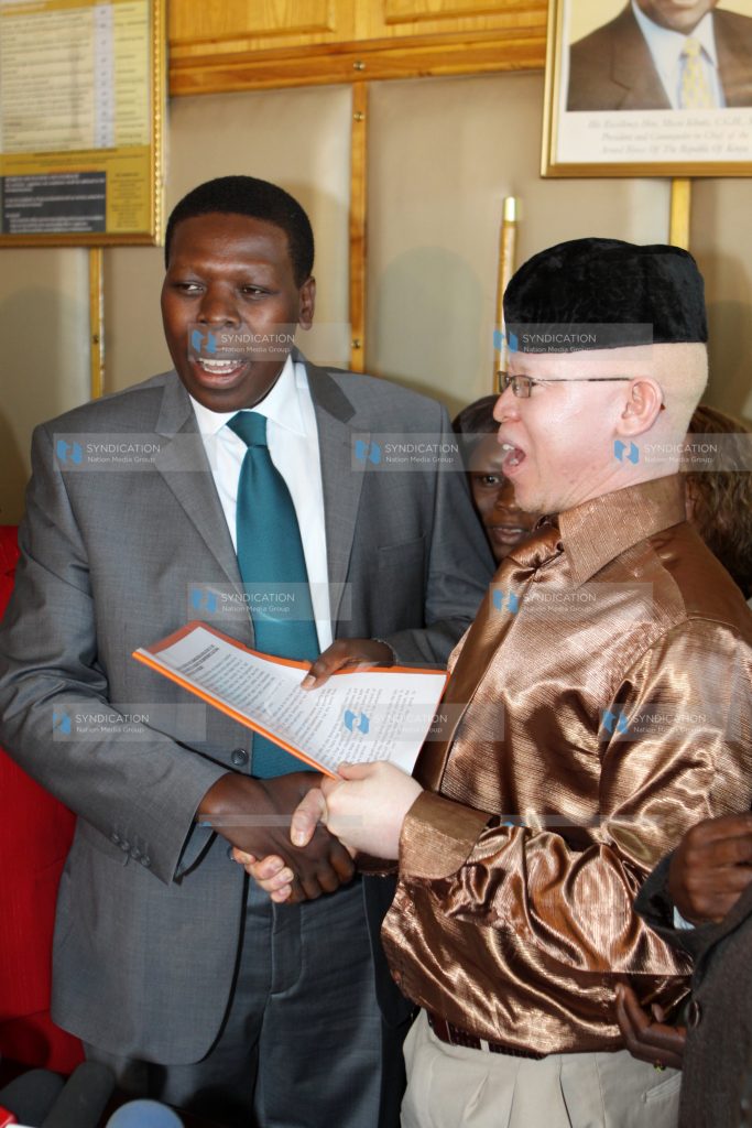 Justice Minister Eugene Wamalwa receives a petition from Isaac Mwaura