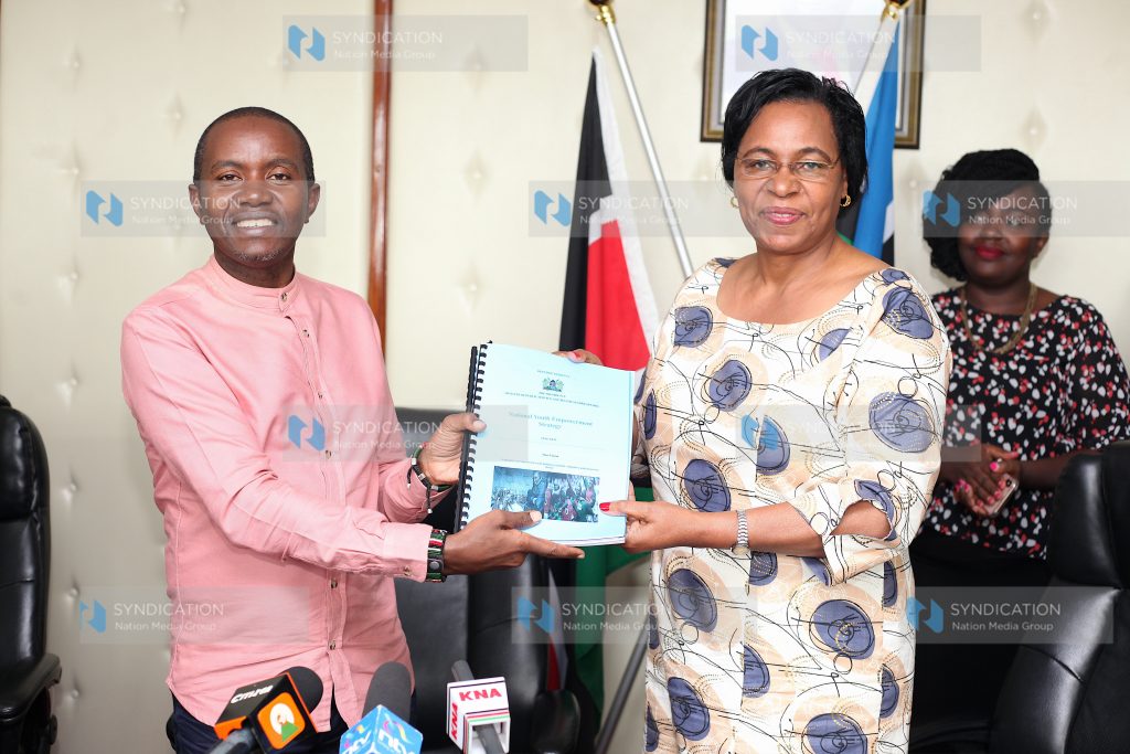 Public Service and Gender Cabinet Secretary Margaret Kobia hands over the youth report to ICT Cabinet Secretary Joe Mucheru