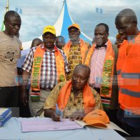 Busia Governor Sospeter Ojaamong signs the "Pesa Mashinani" book in Malaba Town
