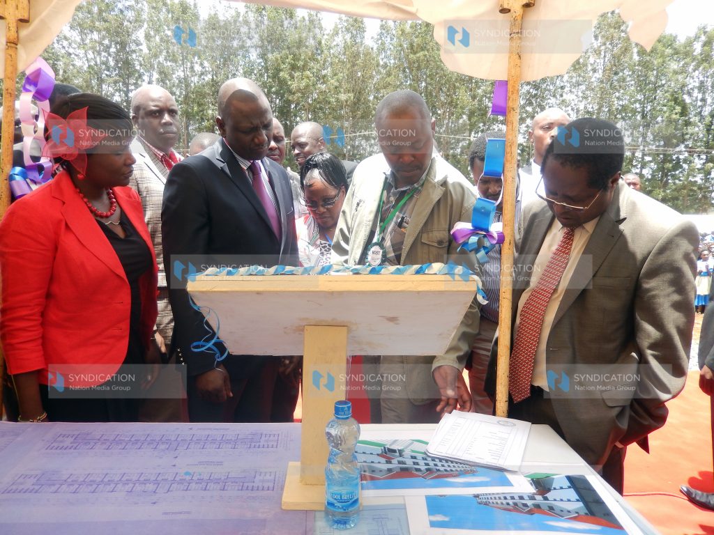 Deputy President William Ruto (second left) looks at the architectural drawing of a dormitory to be built