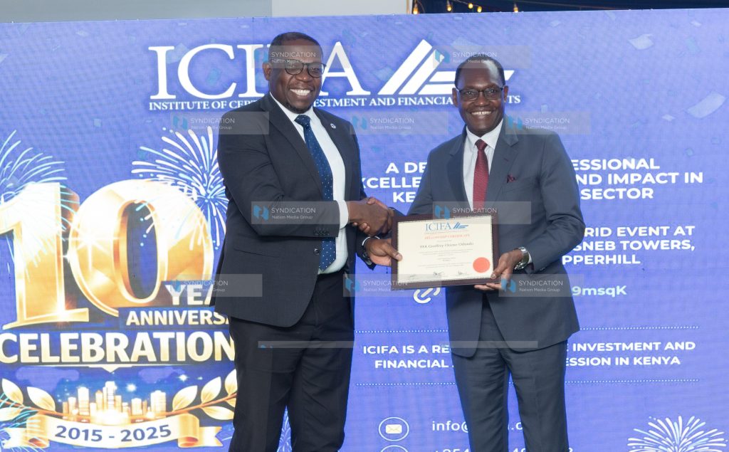 Nation Media Group (NMG) Group Managing Director and CEO Geoffrey Odundo receives an Institute of Certified Investment and Financial Analysts (ICIFA) fellowship certificate from National Treasury Principal Secretary Dr. Chris Kiptoo