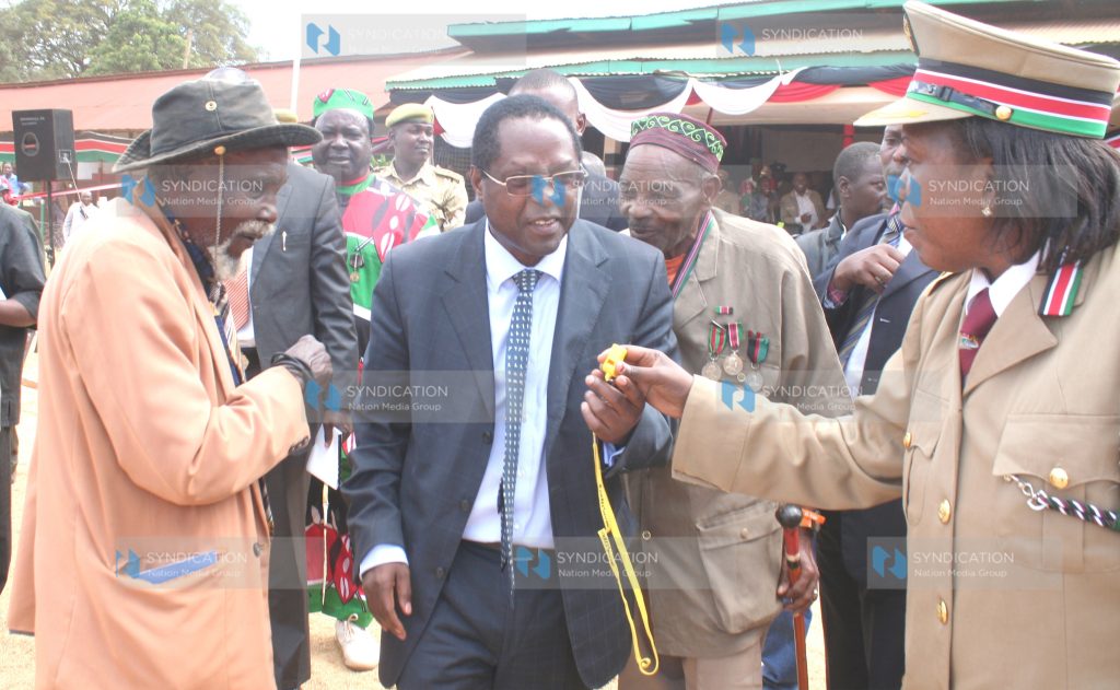 Embu Governor Martin Wambora chats with Eastern Deputy Provincial Commissioner Beverly Opwora and former freedom fighter Peter Nyaga