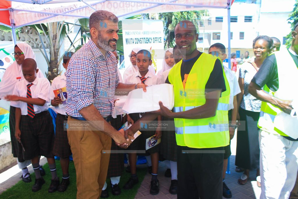 Mvita MP Abdulswamad Shariff Nassir presents packages of success cards to a boda boda rider