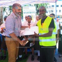 Mvita MP Abdulswamad Shariff Nassir presents packages of success cards to a boda boda rider