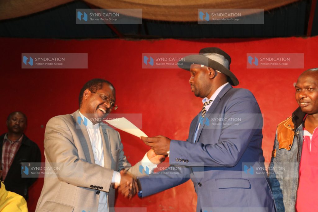 Governor Martin Wambora is handed his interim certificate by Embu County Jubilee Party Returning Officer Kenneth Kamenchu