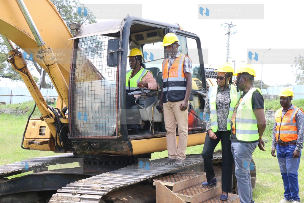 Defence CS Soipan Tuya operates an excavator during the groundbreaking for the completion of Afraha Stadium