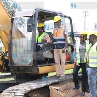 Defence CS Soipan Tuya operates an excavator during the groundbreaking for the completion of Afraha Stadium