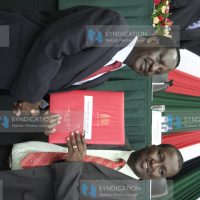 Prime minister Raila Odinga (left) hands over the signed performance contract