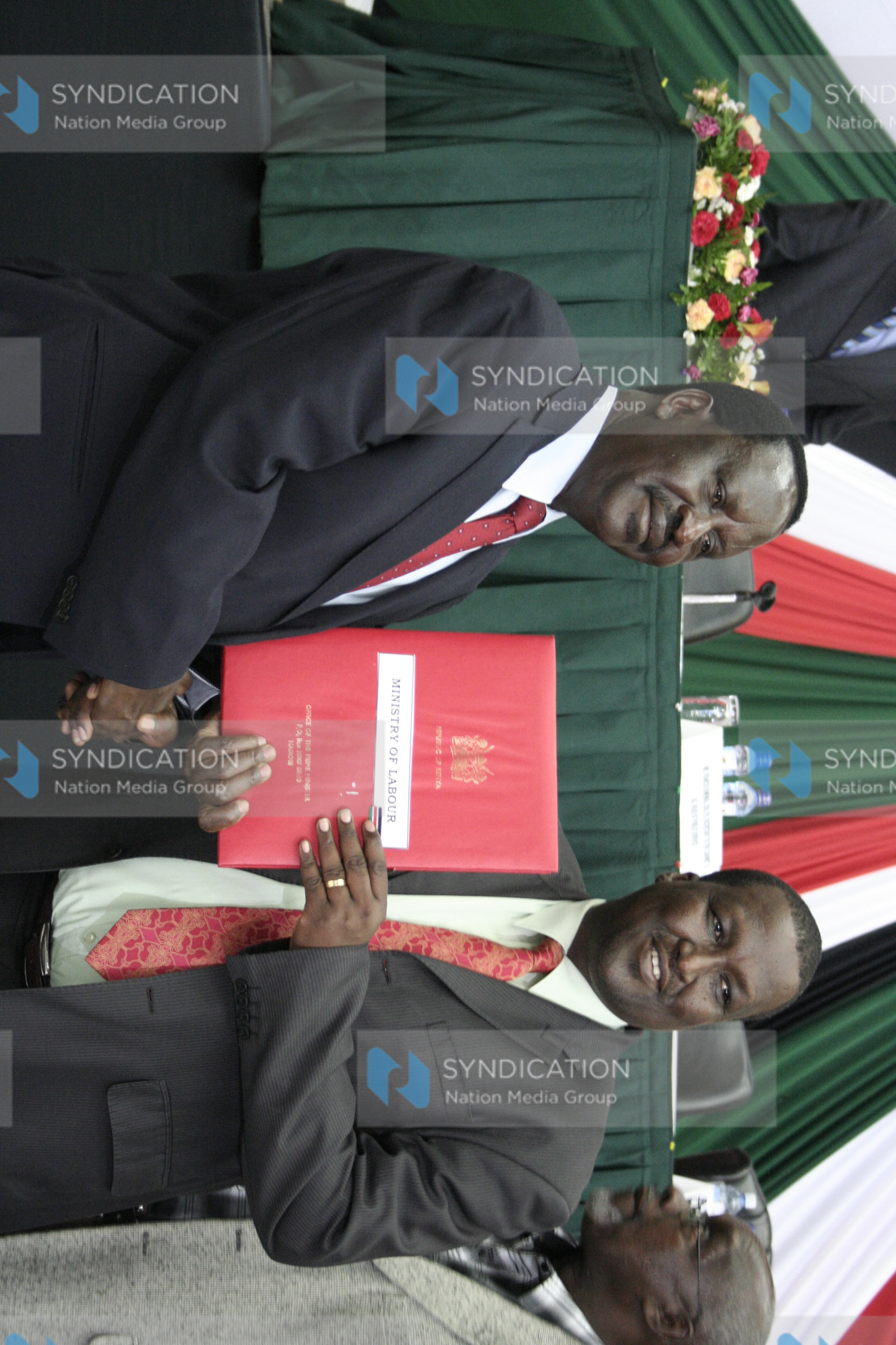 Prime minister Raila Odinga (left) hands over the signed performance contract