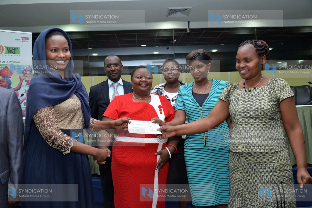 Women Enterprise Fund Advisory Board chairperson, Mumina Bonaya (left) present a cheque of Kshs.500,000/=