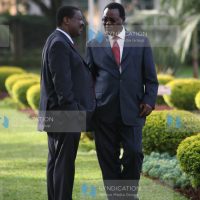 Former finance Minister Musalia Mudavadi (left) and Chris Obure chat
