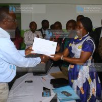 Kisii County Electoral and Boundaries Commission Returning Officer Dr. Sydney Namlanga (left) presents a nomination certificate