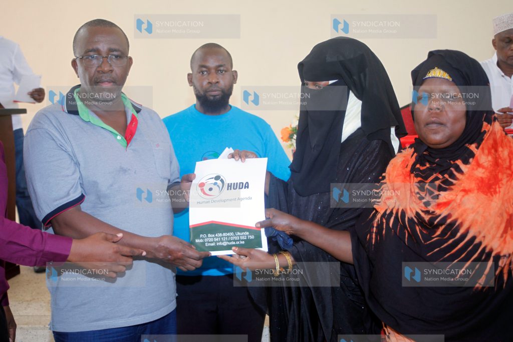 Senator Mithika Linturi receives a report by Human Rights Agenda officials