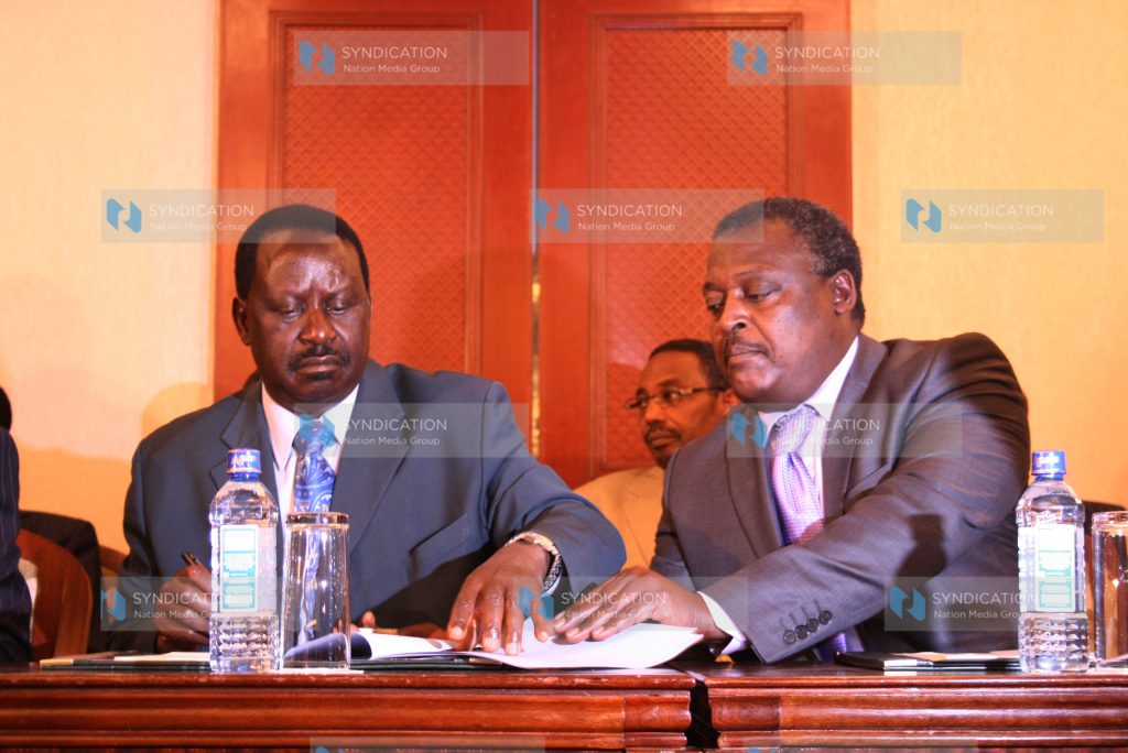 CORD coalition presidential candidate Raila Odinga (left) and Federal Party leader Cyrus Jirongo sign an agreement